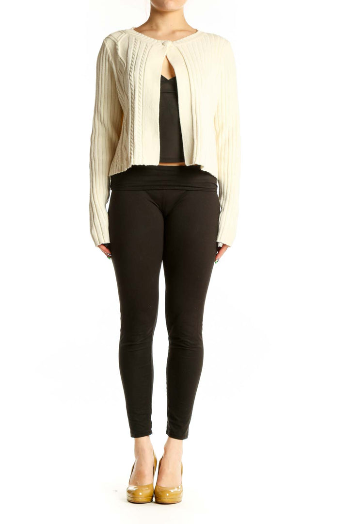 Cream ribbed knit cropped cardigan with cable knit detailing and open front, worn over black top