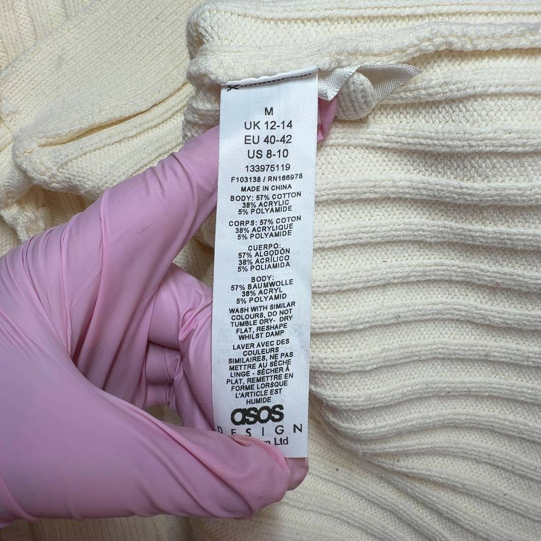 Tag view of cream ribbed knit cropped cardigan showing textured knit pattern and cropped length