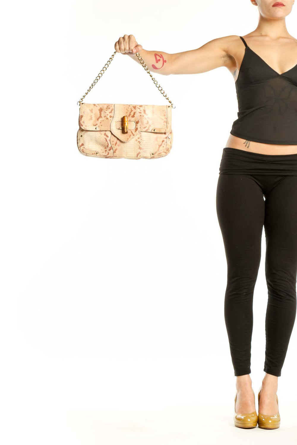 Cream velvet Elaine Turner shoulder bag with dual gold chain straps and bamboo clasp closure, held by hand