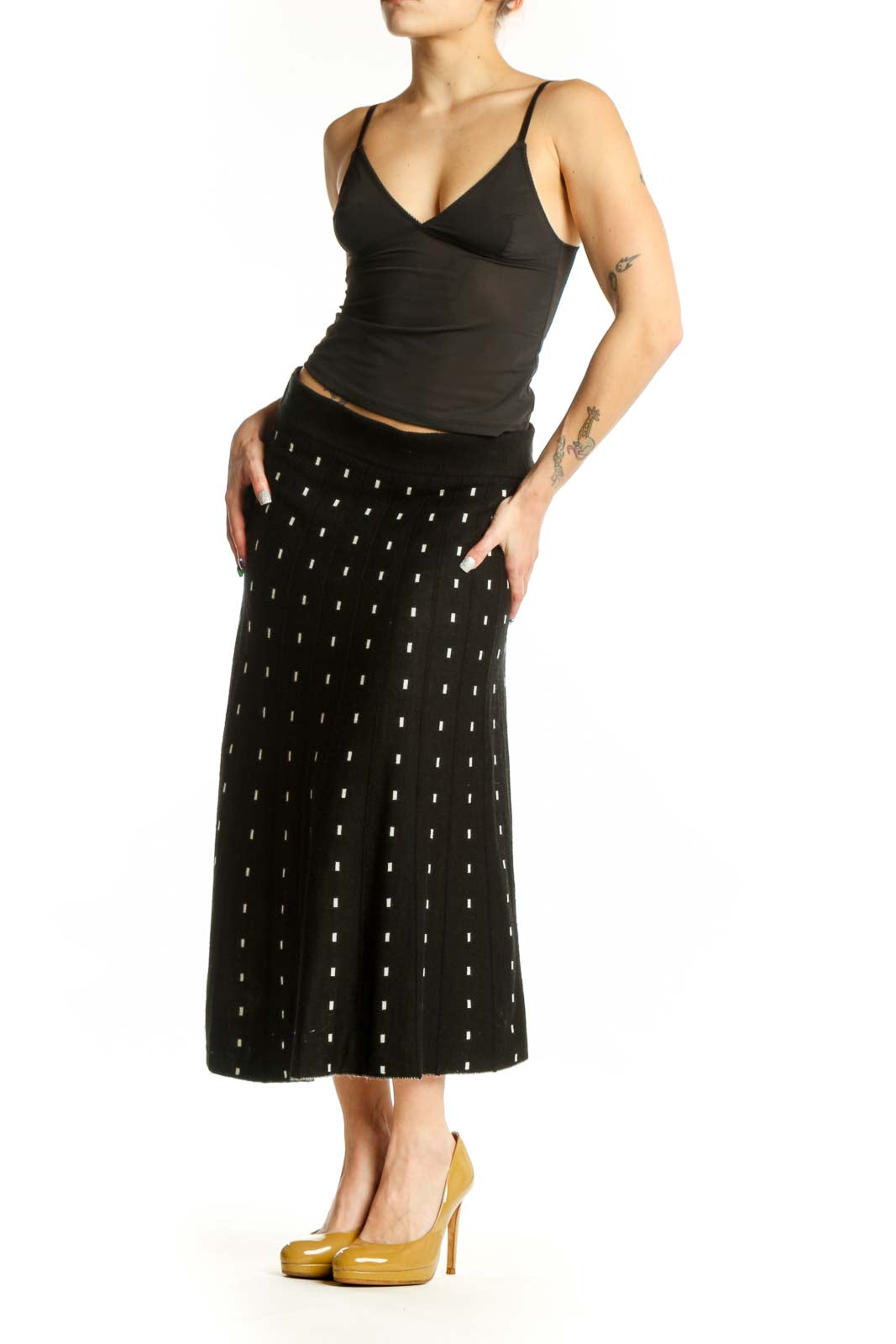 Black A-line midi skirt with white polka dot pattern, front view