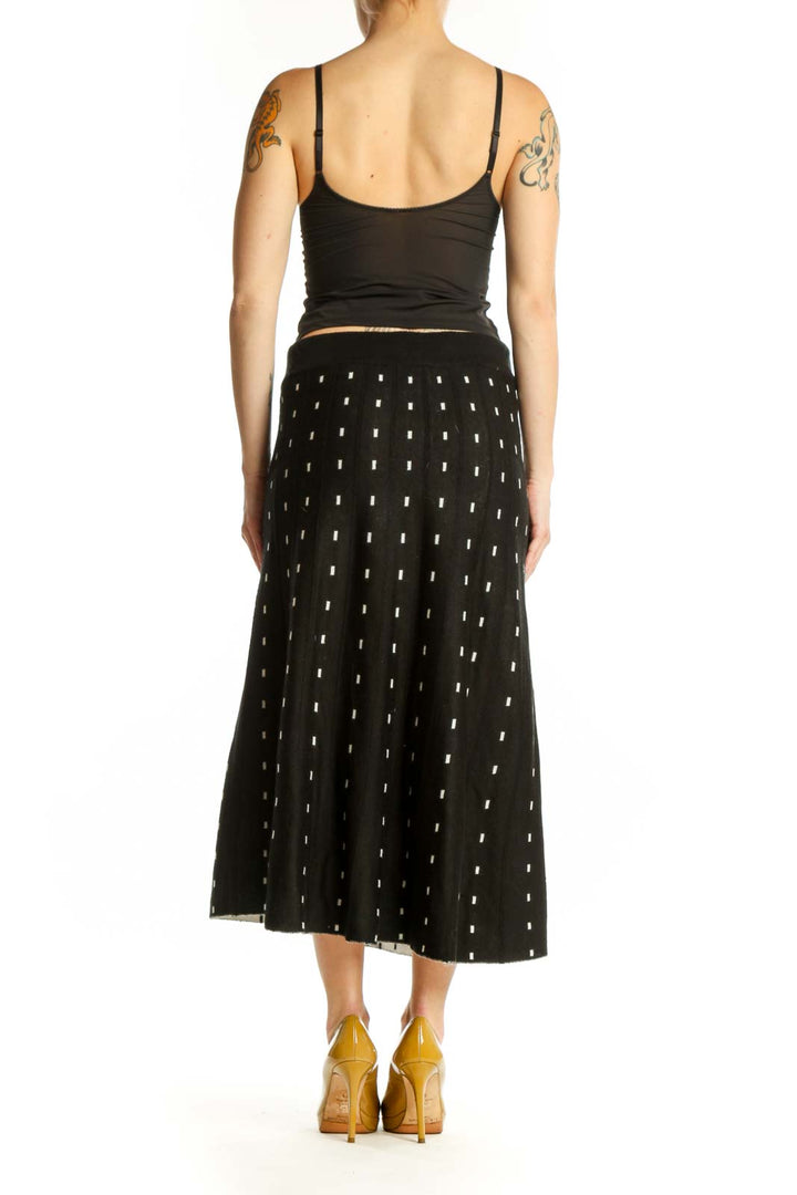 Black A-line midi skirt with white polka dot pattern, back view