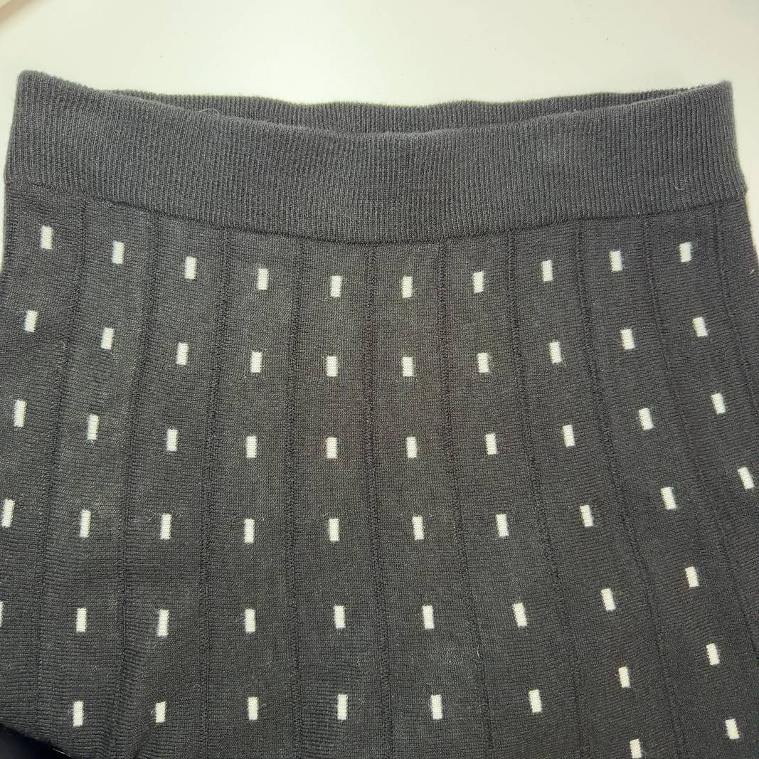 Black A-line midi skirt with white polka dot pattern, back view