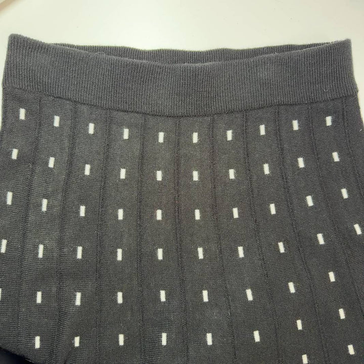 Black A-line midi skirt with white polka dot pattern, back view