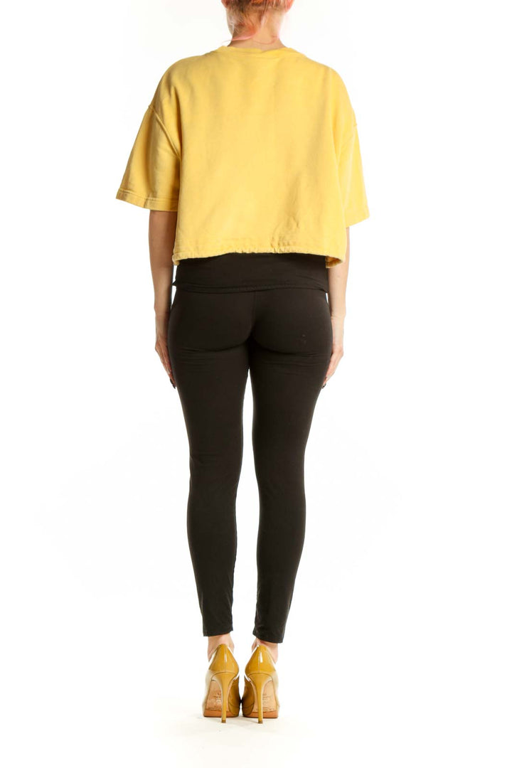 Yellow Nike cropped athletic t-shirt back view showing relaxed fit and cropped length