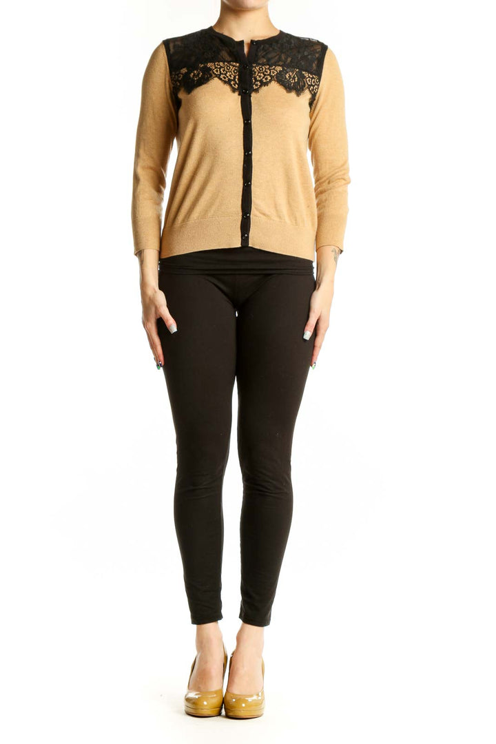 Beige cardigan with black lace trim neckline, three-quarter sleeves, and button-front closure