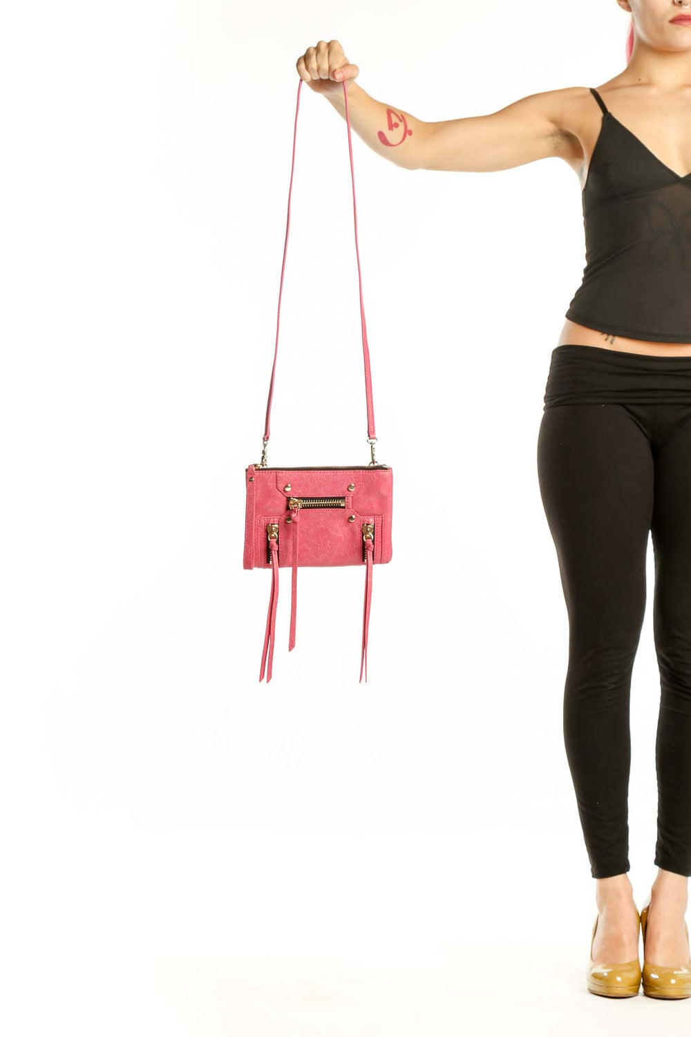 Coral pink Botkier leather crossbody bag with gold hardware and fringe details, shown with adjustable pink leather strap