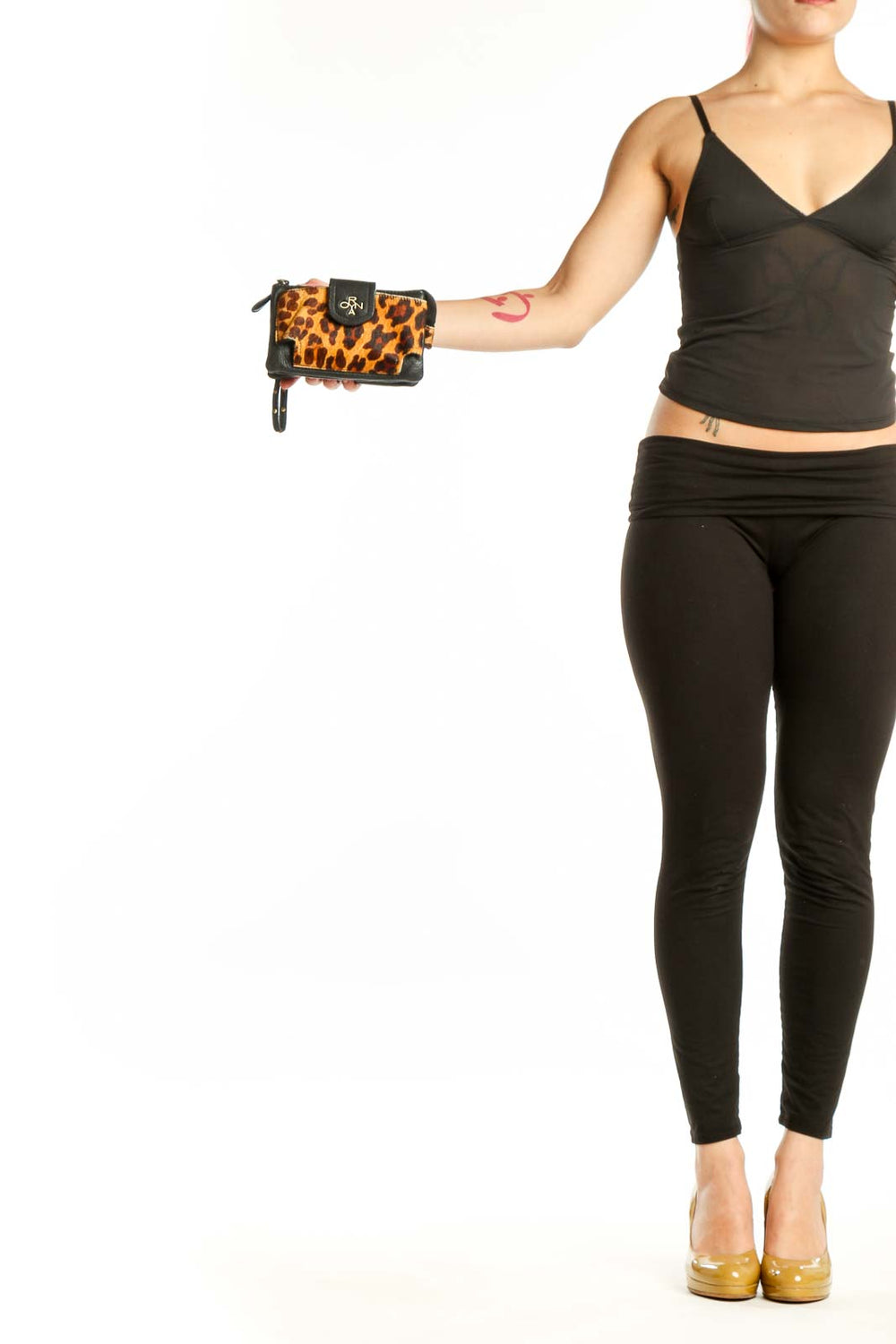 ORYAN orange and black leopard print clutch with black leather trim and wristlet strap, held in hand