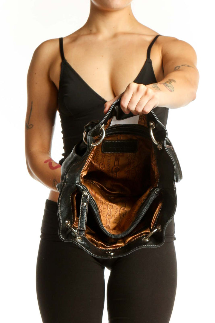 Back view of black leather Tignanello shoulder tote bag worn on shoulder showing spacious interior and quality construction