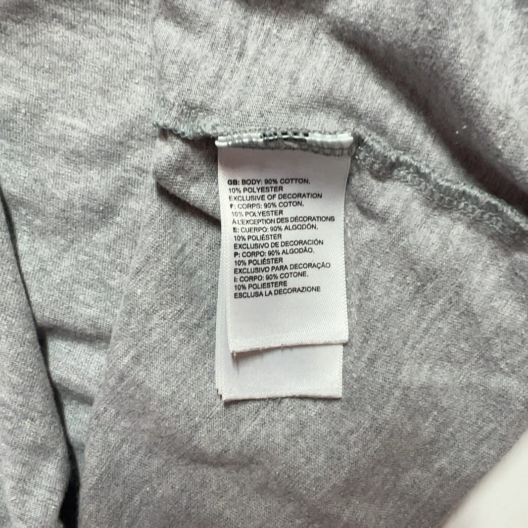 Tag view of gray long sleeve The North Face top showing white logo, paired with black leggings