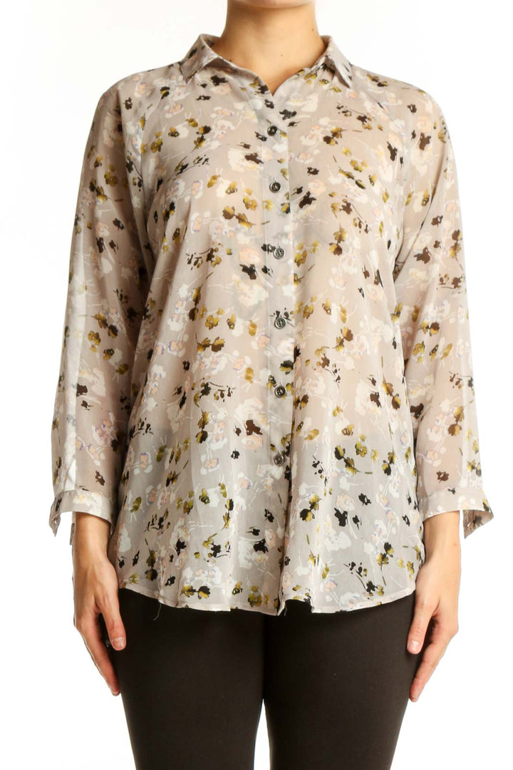 Cream floral print button-up shirt with gold and black botanical pattern, long sleeves, and classic collar on model