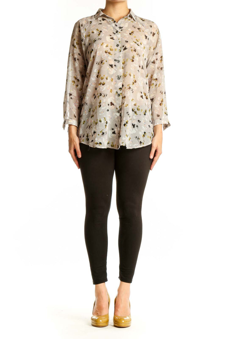 Cream floral print button-up shirt with gold and black botanical pattern, long sleeves, and classic collar on model