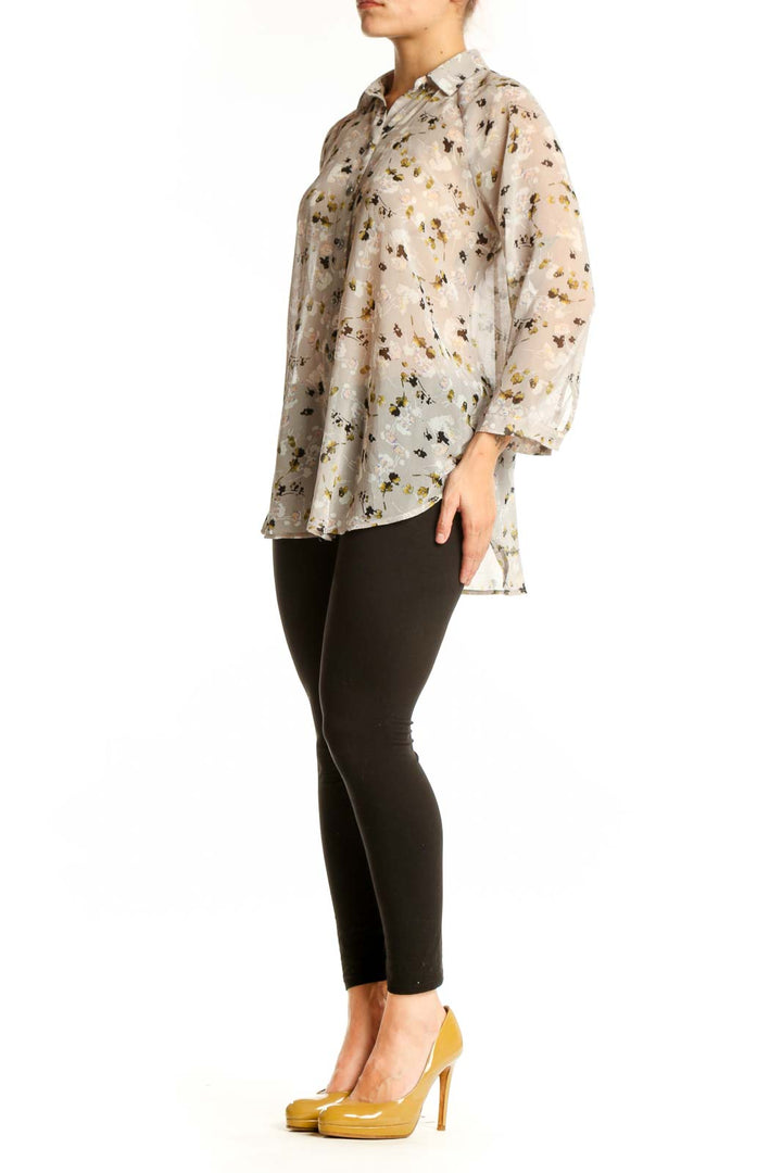Cream floral print button-up shirt with gold and black botanical pattern, long sleeves, and classic collar on model
