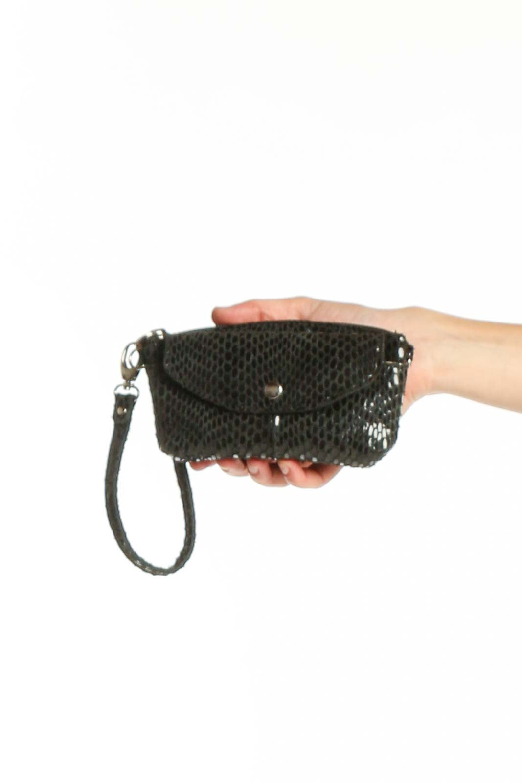 Black mesh crossbody bag XS by Sorial New York with wrist strap and snap closure, held in hand