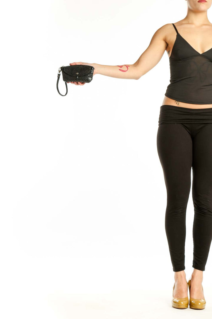Black mesh crossbody bag XS by Sorial New York with wrist strap and snap closure, held in hand