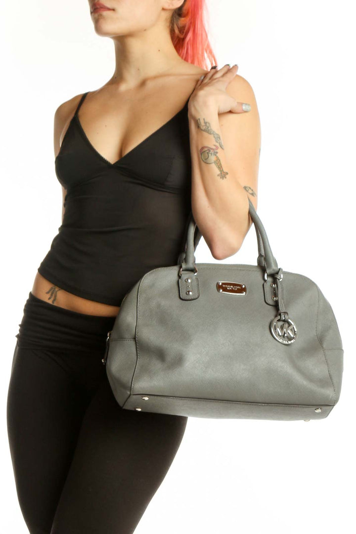 Gray Michael Kors dome tote bag with dual handles and MK charm, front view