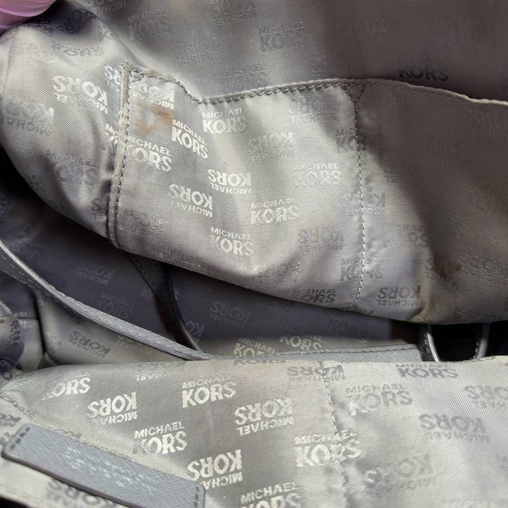 Gray Michael Kors dome tote bag displayed on model, side view showing structured silhouette