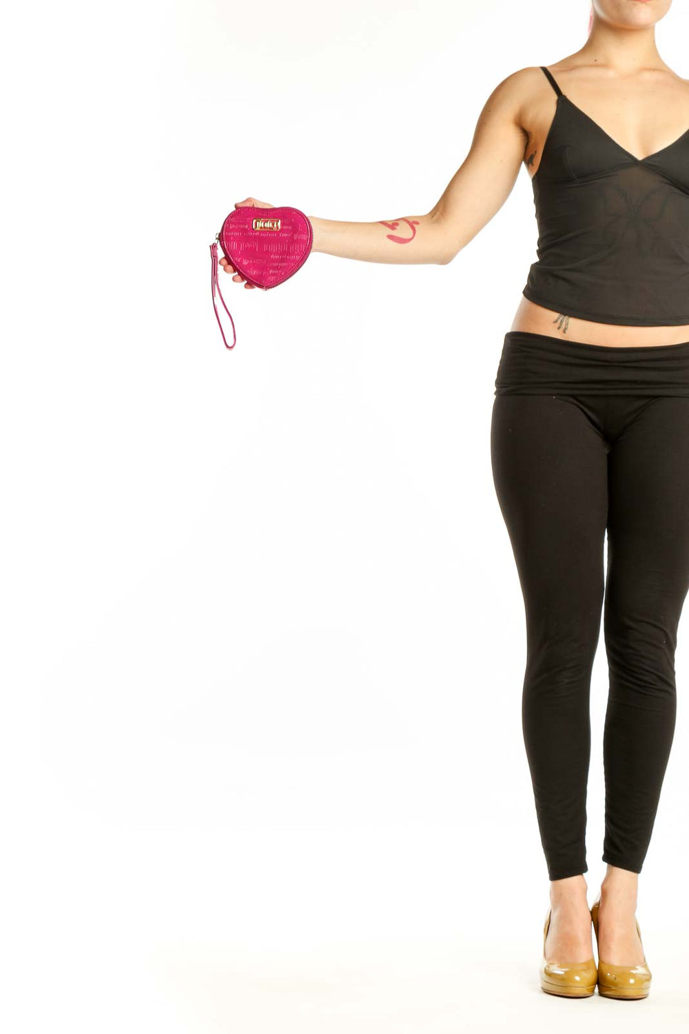Pink heart-shaped Juicy Couture clutch with quilted texture and wrist strap held in hand