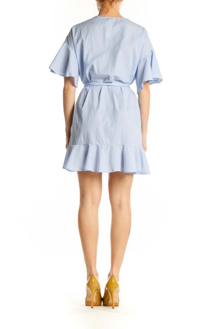 Light blue striped wrap dress with flutter sleeves and asymmetrical ruffle hem, back view