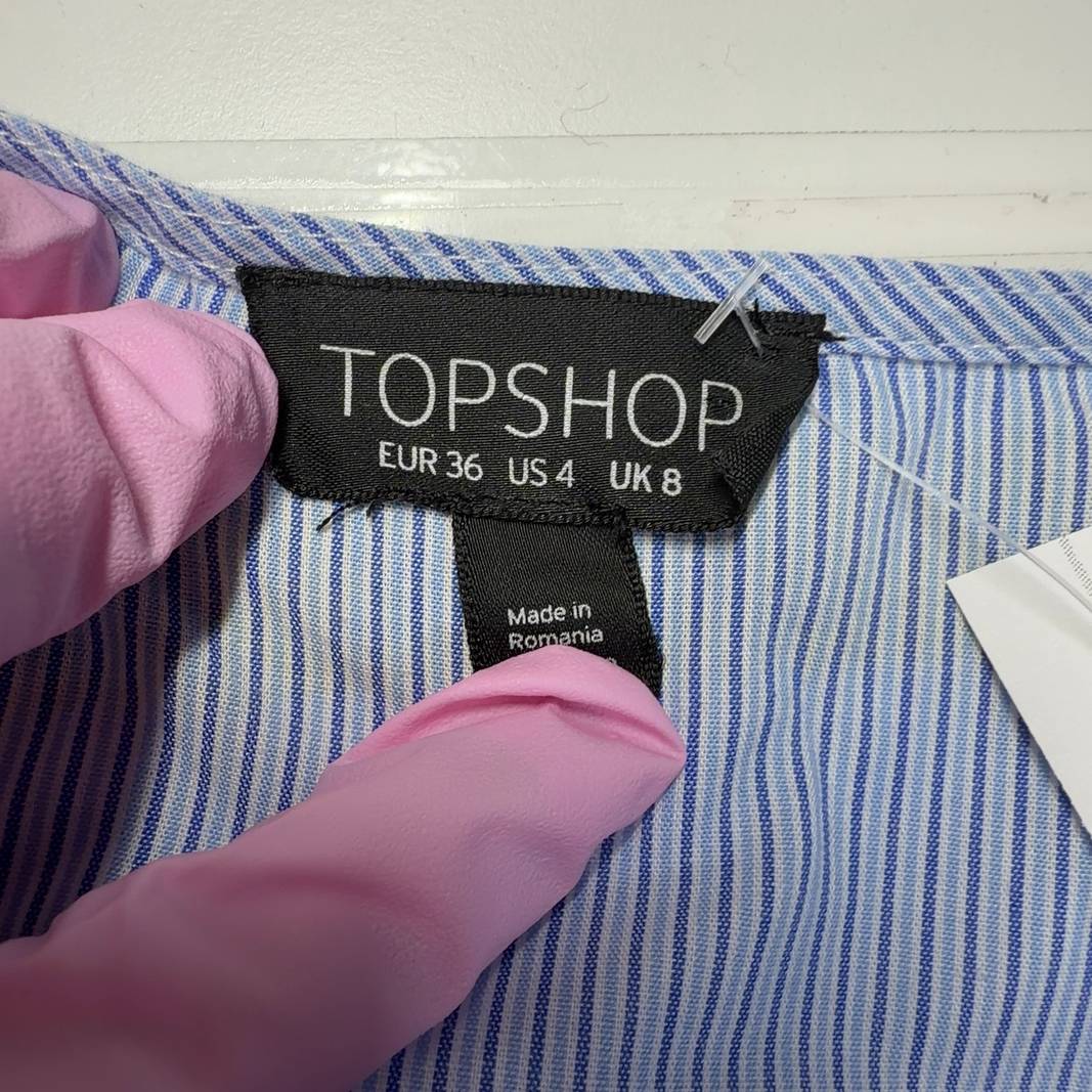 Light blue striped wrap dress with flutter sleeves and asymmetrical ruffle hem, back view