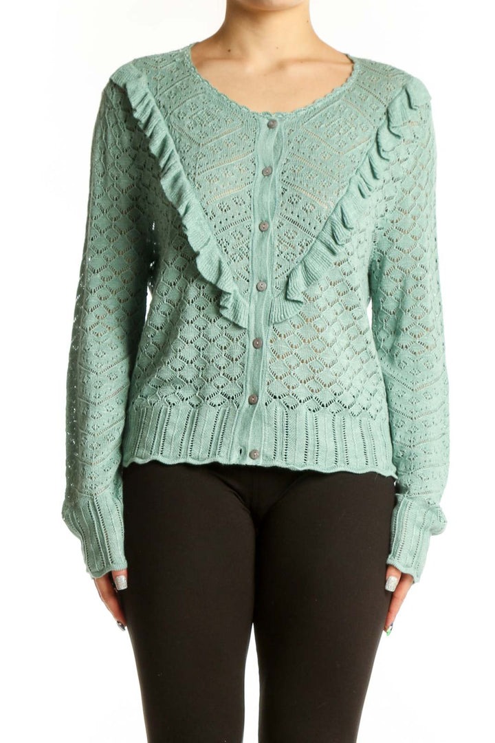 Sage green Sundance cardigan with ruffle detailing on front, worn with black pants