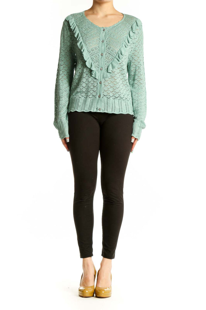 Sage green Sundance cardigan with ruffle detailing on front, worn with black pants