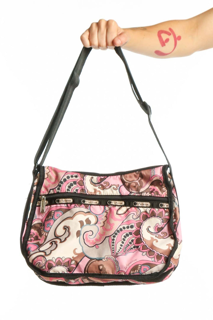 Pink paisley Lesportsac crossbody bag with black adjustable strap and multiple organizational pockets, front view
