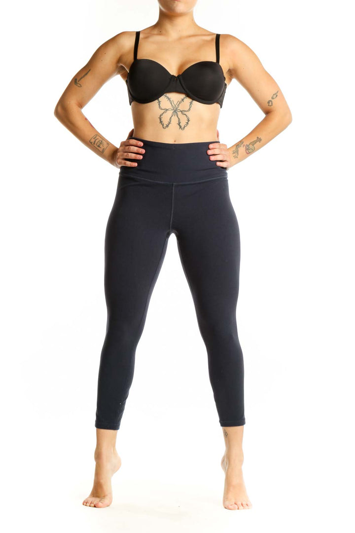 Black high-waist capri leggings front view showing fitted silhouette and wide waistband