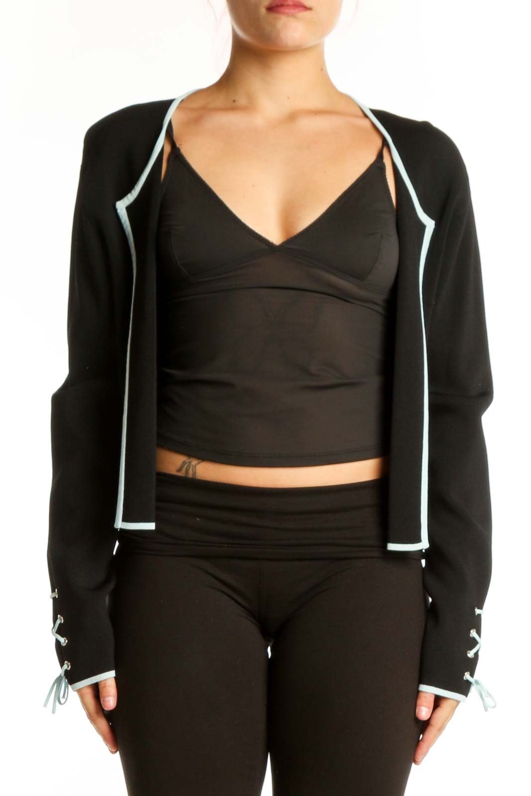 Black cropped zip-up jacket with white trim and adjustable cuffs, front view on model
