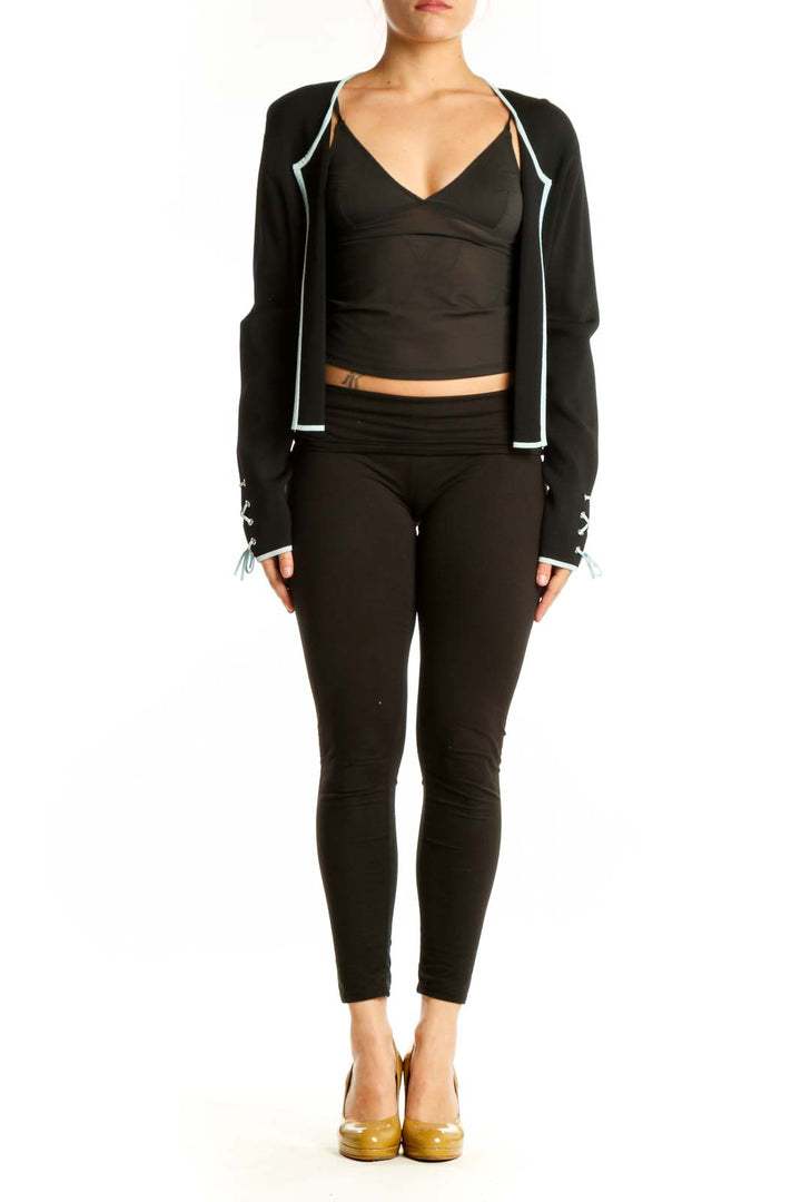 Black cropped zip-up jacket with white trim and adjustable cuffs, front view on model