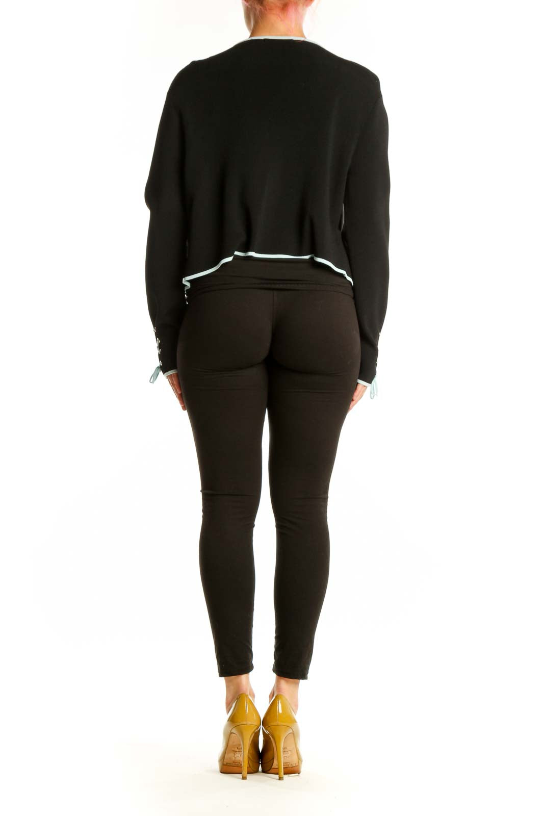 Black cropped zip-up jacket with white piping, back view on model wearing black leggings