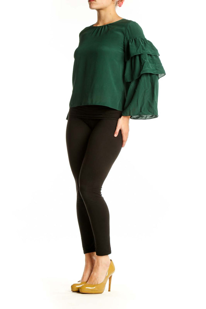 Forest green silk blouse with tiered ruffle sleeves, cropped fit, worn with black pants