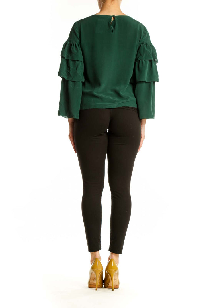 Back view of green silk ruffle sleeve blouse showing layered sleeve detail and relaxed silhouette