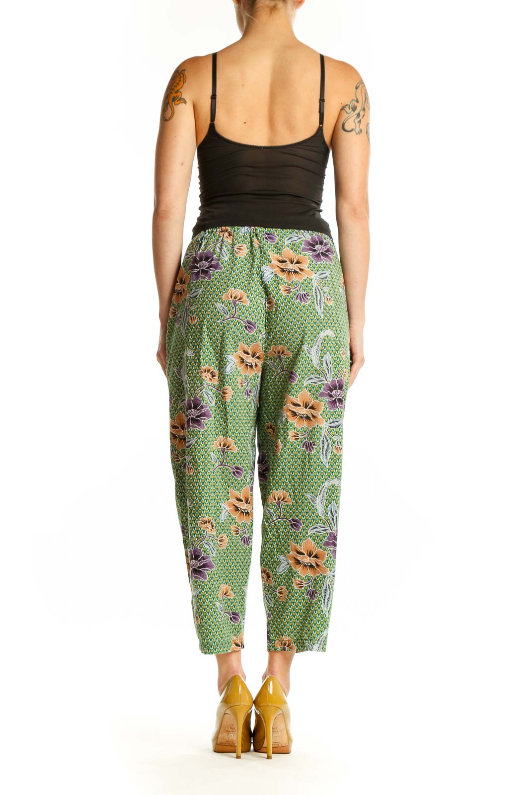 Back view of green floral cropped pants showing the full botanical design and relaxed tapered silhouette