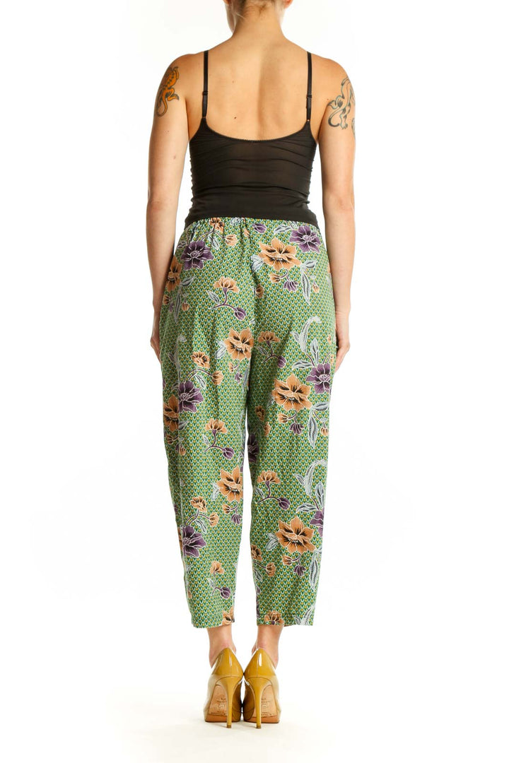 Back view of green floral cropped pants showing the full botanical design and relaxed tapered silhouette