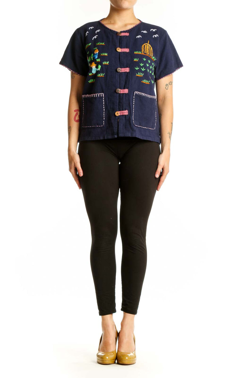 Navy SilkRoll embroidered button-up top with colorful hand-stitched designs including children, suns, and grass motifs, coral buttons, and white stitched patch pockets