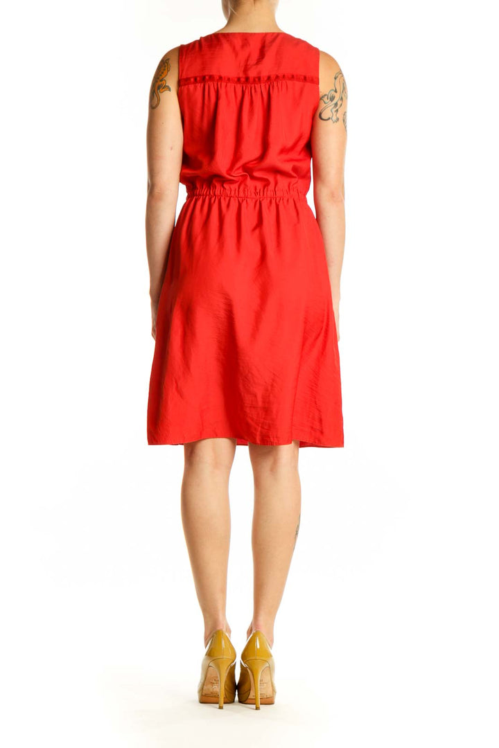Red sleeveless A-line dress with cinched waist and side pockets, back view