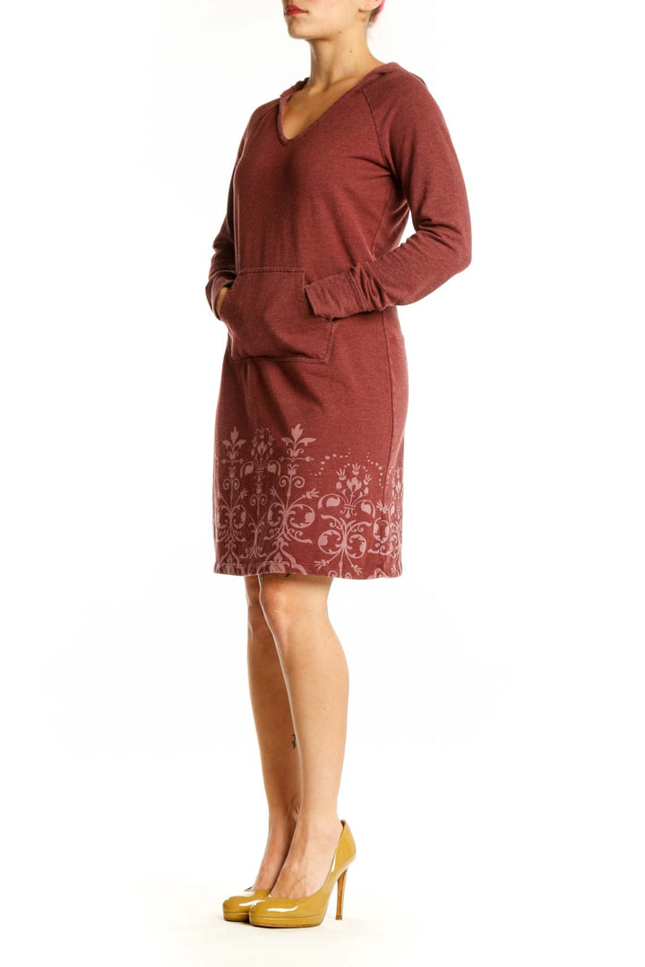 Burgundy hooded dress with damask print pattern on lower portion, featuring long sleeves and front pockets
