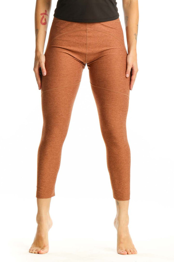 Front view of orange heathered cropped leggings with high-waisted fit and calf-length cut