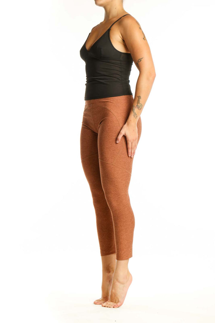 Front view of orange heathered cropped leggings with high-waisted fit and calf-length cut