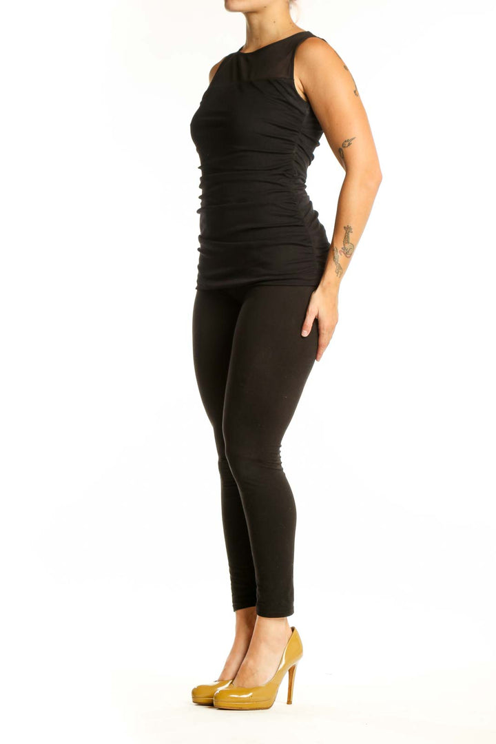 Black ruched sleeveless tank top with mesh neckline panel, front view on model