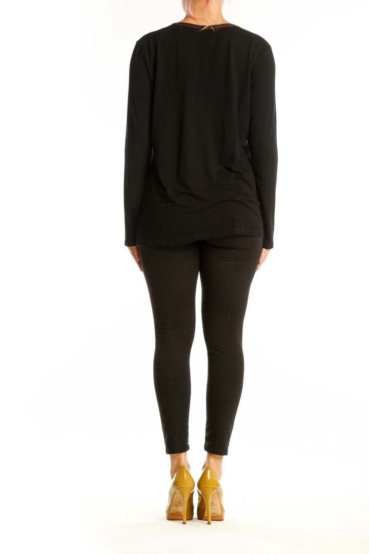 Back view of black mixed pattern long sleeve top showing leopard print side panels and patchwork design
