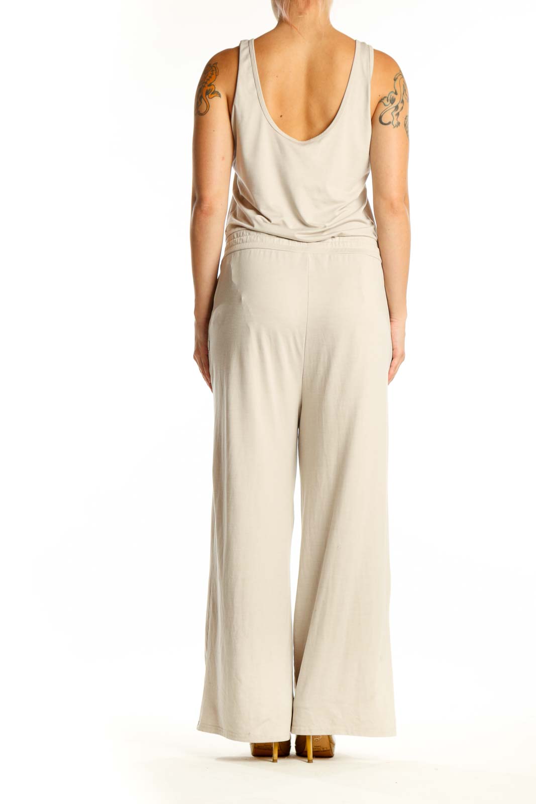 Back view of cream sleeveless jumpsuit showing relaxed fit and side pockets