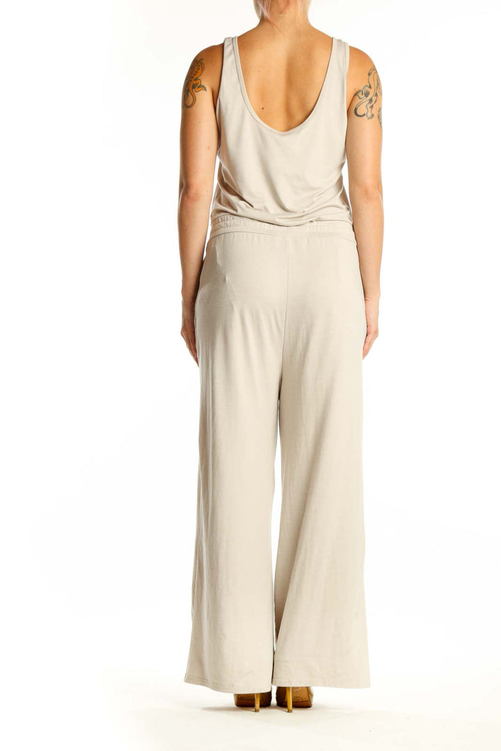 Back view of cream sleeveless jumpsuit showing relaxed fit and side pockets