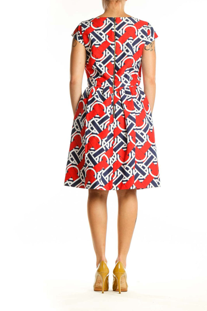 Red, navy, and white geometric print A-line dress with V-neckline and cap sleeves, back view
