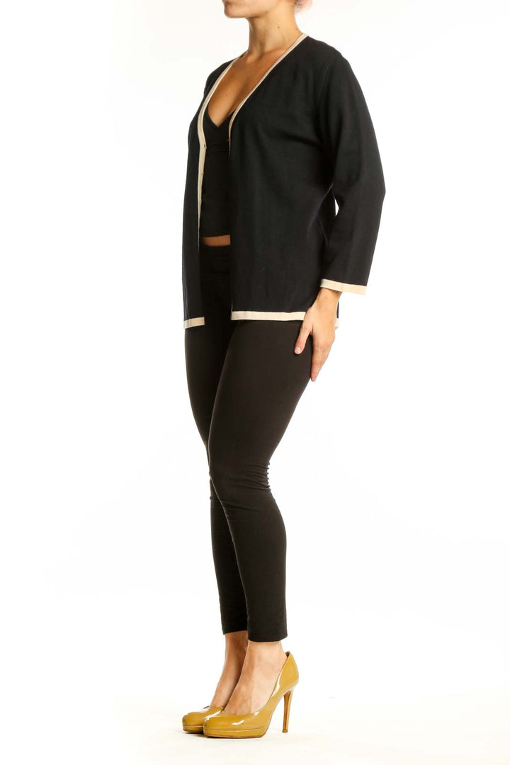 Black wool ESCADA cardigan with cream trim, V-neckline, and button-front closure worn over black top