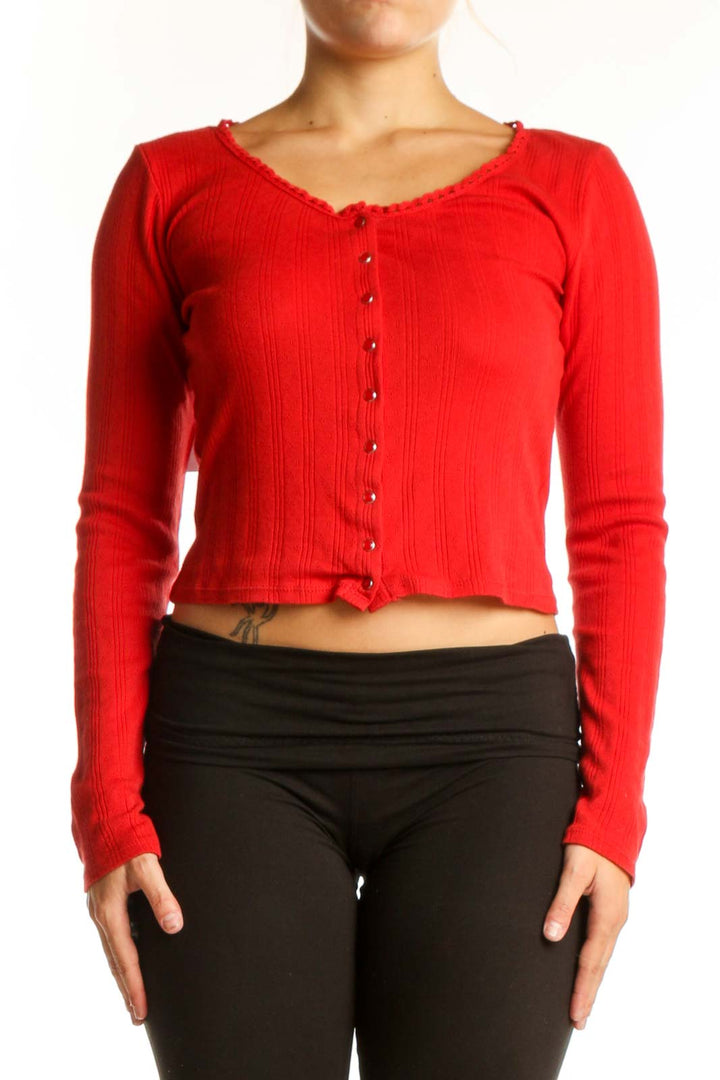 Red ribbed cotton crop cardigan with button-front closure, worn with black leggings