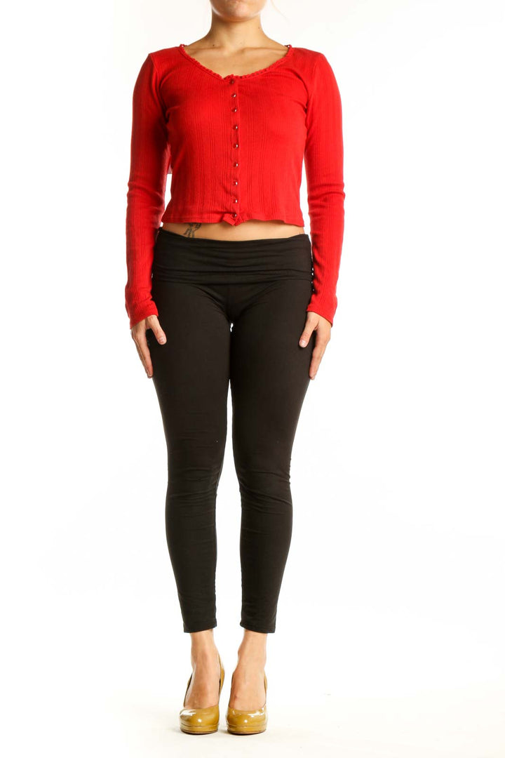 Red ribbed cotton crop cardigan with button-front closure, worn with black leggings