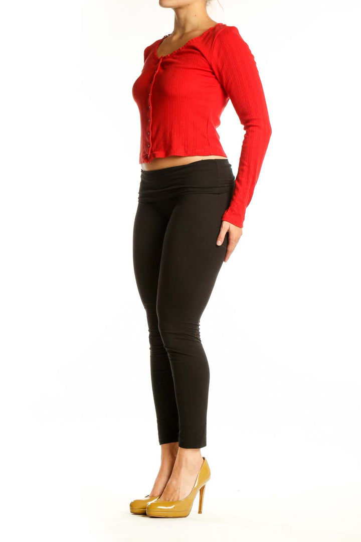 Red ribbed cotton crop cardigan with button-front closure, worn with black leggings