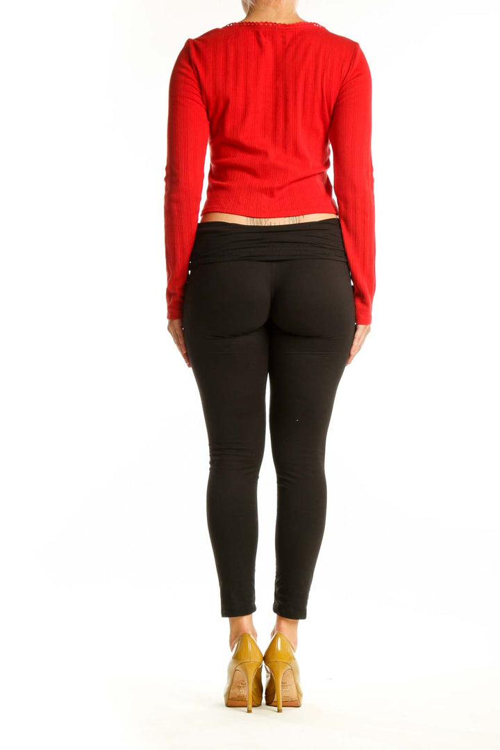 Back view of red ribbed cotton crop cardigan showing fitted silhouette and cropped length