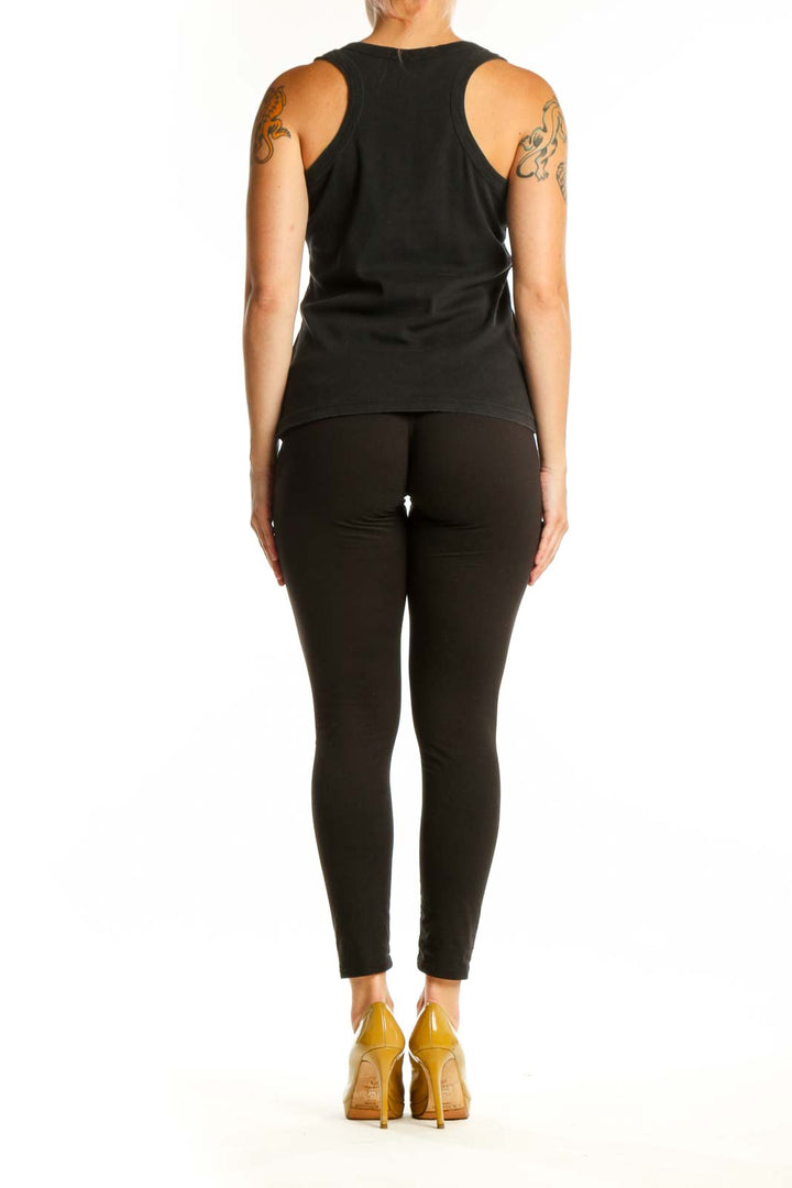 Black Paris tank top back view showing side profile fit on model wearing black leggings